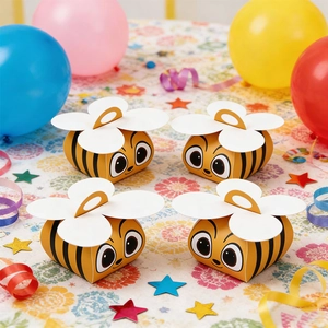 Detail of bee shaped party gift boxes with yellow and black stripes and white flower handles
