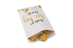 Macro view of Bee Festival paper gift bags featuring honey bee prints and cookie content
