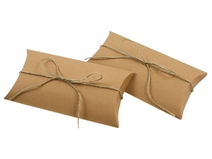Dettaglio macro di scatole regalo a cuscino in carta kraft con spago naturale e trama rustica
