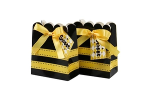 Detail of bee themed party favor boxes with black yellow stripes and Sweet gift tags