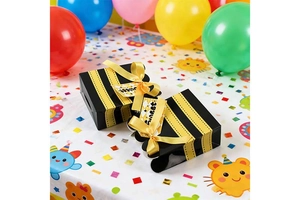 Detail of bee themed candy boxes with black yellow stripes and yellow silk bow ties