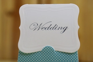 Detail of wedding favor box with blue polka dot base and embossed 'Wedding' card holder