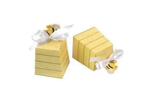 Detail of bee-themed candy boxes with honeycomb patterns and white satin ribbons