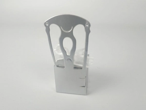 Detail of silver chair-shaped candy box with hollow design and white organza ribbon bow