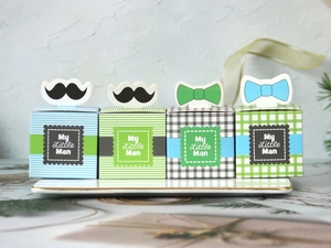Detail of My Little Man candy boxes with bow tie and mustache on ceramic tray