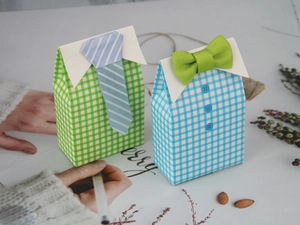 Detail of plaid shirt style favor boxes with blue tie and green bow tie decorations