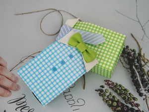 Macro shot of creative shirt-shaped wedding candy boxes with plaid patterns and bow ties