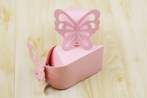 Close-up of pink butterfly pearl paper gift box in creative cake slice shape