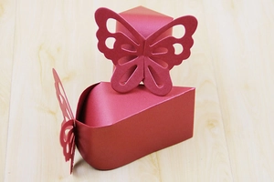 Detailed laser-cut butterfly design on dark red pearlescent paper candy gift box
