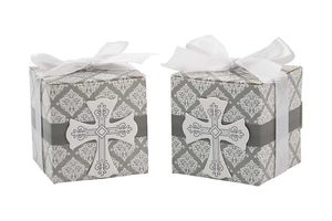 Detail view of two grey religious favor boxes with white cross and satin ribbon bows