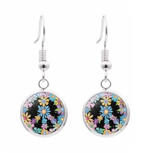 Detail of silver drop earrings featuring colorful floral patterns under glass cabochons