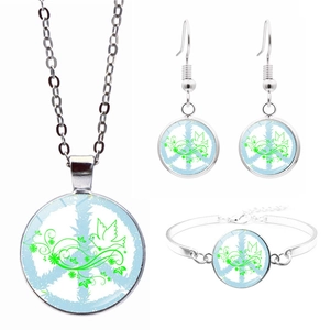 Detailed set of silver peace sign jewelry featuring green dove and floral motifs