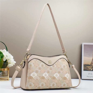 Close-up of contrast patchwork texture and retro floral metal logo on cream shoulder bag