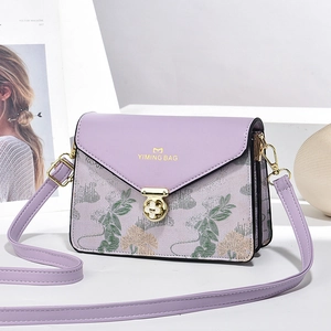 Detail of lavender purple crossbody bag featuring floral embroidery and gold metal lock