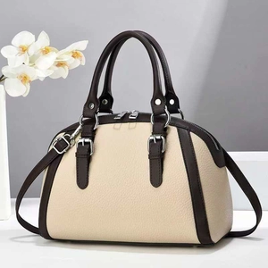 Chic two-tone Boston bag in beige and dark brown leather with silver hardware and strap