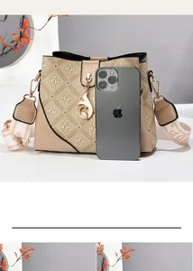 Detail of vintage bucket bag with embroidered strap and phone for size comparison