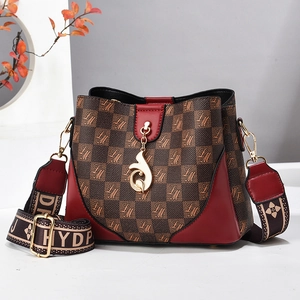 Fashionable bucket bag with brown monogram pattern and vibrant red contrast details