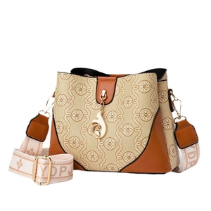 Chic monogrammed bucket bag in beige jacquard with brown leather trim and wide strap