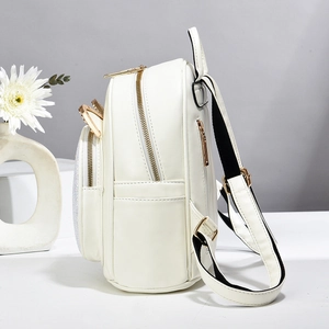 Detalle de mini mochila de cuero blanco con diseño de orejas de gato y cremalleras doradas