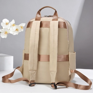 Detail view of the padded shoulder straps and back structure of this beige travel backpack