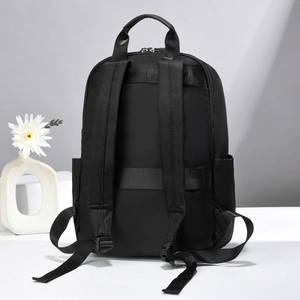 Black lightweight travel backpack with luggage strap and padded straps on white stand