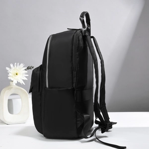 Side view of black nylon backpack featuring reinforced handle and hidden zipper pocket