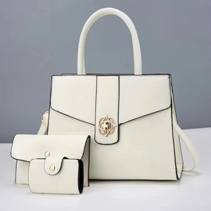 Three-piece women handbag set in cream white with gold floral metal clasp and black trim