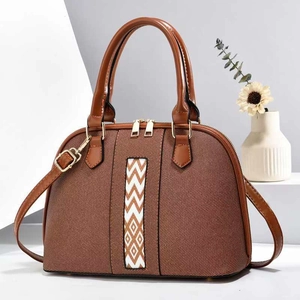 Detail of a brown Boston bag showing geometric color-block stripes and gold hardware