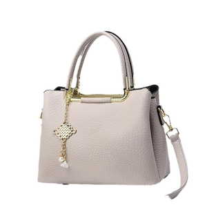 Elegante borsa a mano da donna in morbida pelle con trama a grana e ciondolo decorativo
