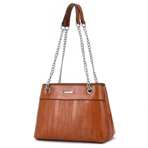 Detail of caramel striped crossbody bag featuring textured pattern and silver chain strap