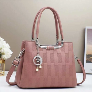 Detailaufnahme der pinken PU-Lederhandtasche mit Webstruktur und Sternenanhänger