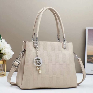 Detail of cream macaron crossbody bag with brick-pattern texture and star-pearl charms