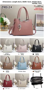 Detailed view of embossed handbag features including star charm and internal zip structure