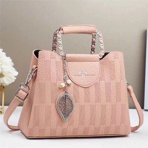 Detail view of pink plaid bucket bag with pearl leaf charm and chain handle