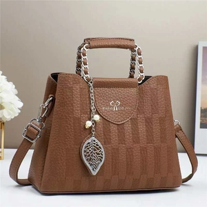 Brown checkered bucket bag with leaf charm, metal chain handle, and crossbody strap