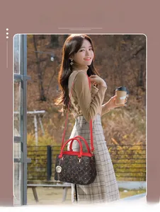 Outdoor lifestyle shot of a printed tote bag with red handles and metal charm detail
