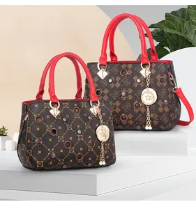 Detail of monogram leather tote bags with red handles and pearl tassel charms