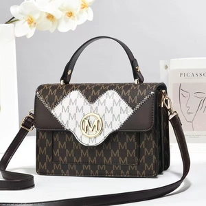 Detail of square handbag showing monogram pattern, gold logo buckle, and accordion sides
