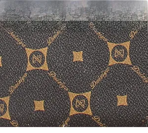 Close-up of brown synthetic leather with golden geometric star patterns and grain texture