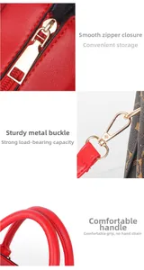 Detailed view of smooth zippers, gold hardware, and sturdy handles on the red bag