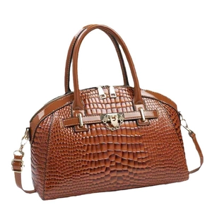 Sac à main marron effet crocodile avec détails dorés et bandoulière sur fond blanc