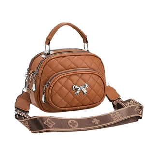 Sac bandoulière matelassé marron avec motif losanges, breloque nœud et large bandoulière