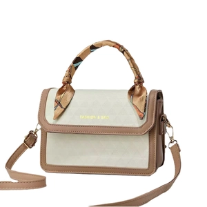 Chic color-block shoulder bag with geometric quilted texture and silk scarf handle