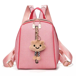 Detail of pink striped backpack featuring a plush bear charm and gold zipper accents