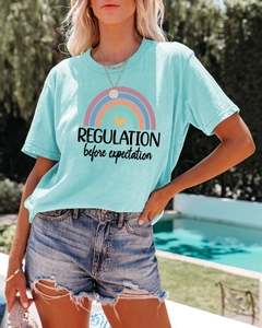 Close-up of light blue cotton T-shirt featuring rainbow print and text for women