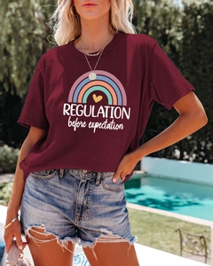 Detail of burgundy t-shirt with rainbow and heart print paired with denim shorts by pool