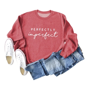 Détail à plat d'un sweat rouge brique avec inscription blanche et style décontracté chic