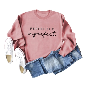 Mise à plat de sweat rose avec impression PERFECTLY imperfect et jean en denim