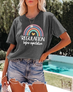 Detail of gray cotton T-shirt featuring rainbow print and expectation text in summer setting