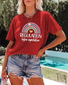 Detail of red T-shirt with rainbow and heart print paired with distressed denim shorts